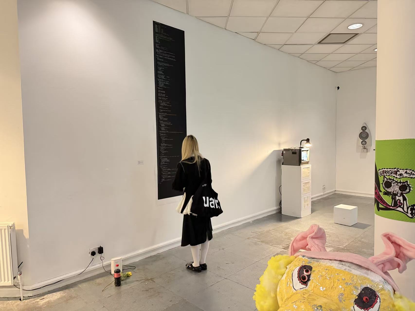 A visitor standing in front of This Is Not Code in the gallery