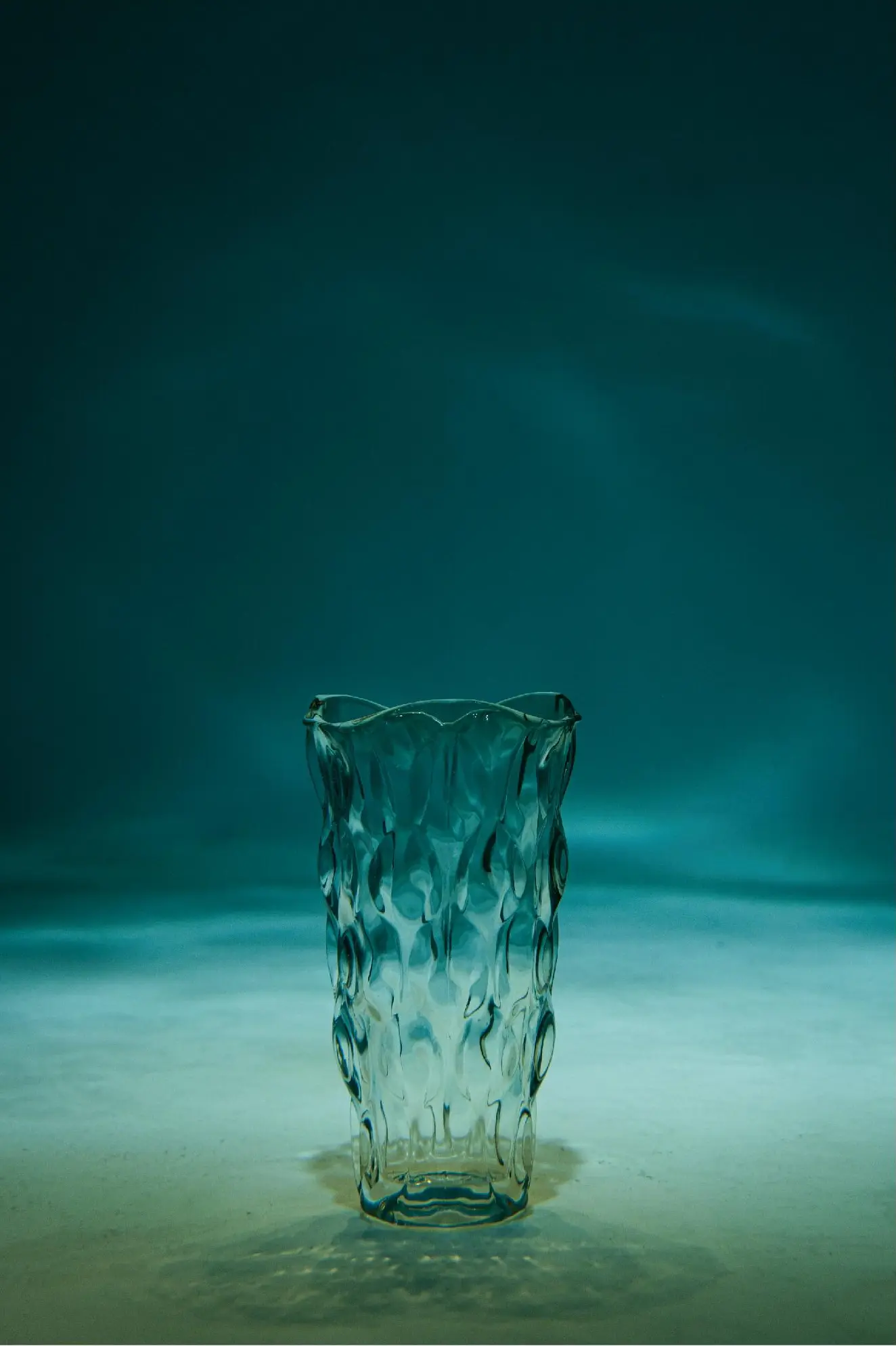 An empty glass vessel standing beneath underwater light