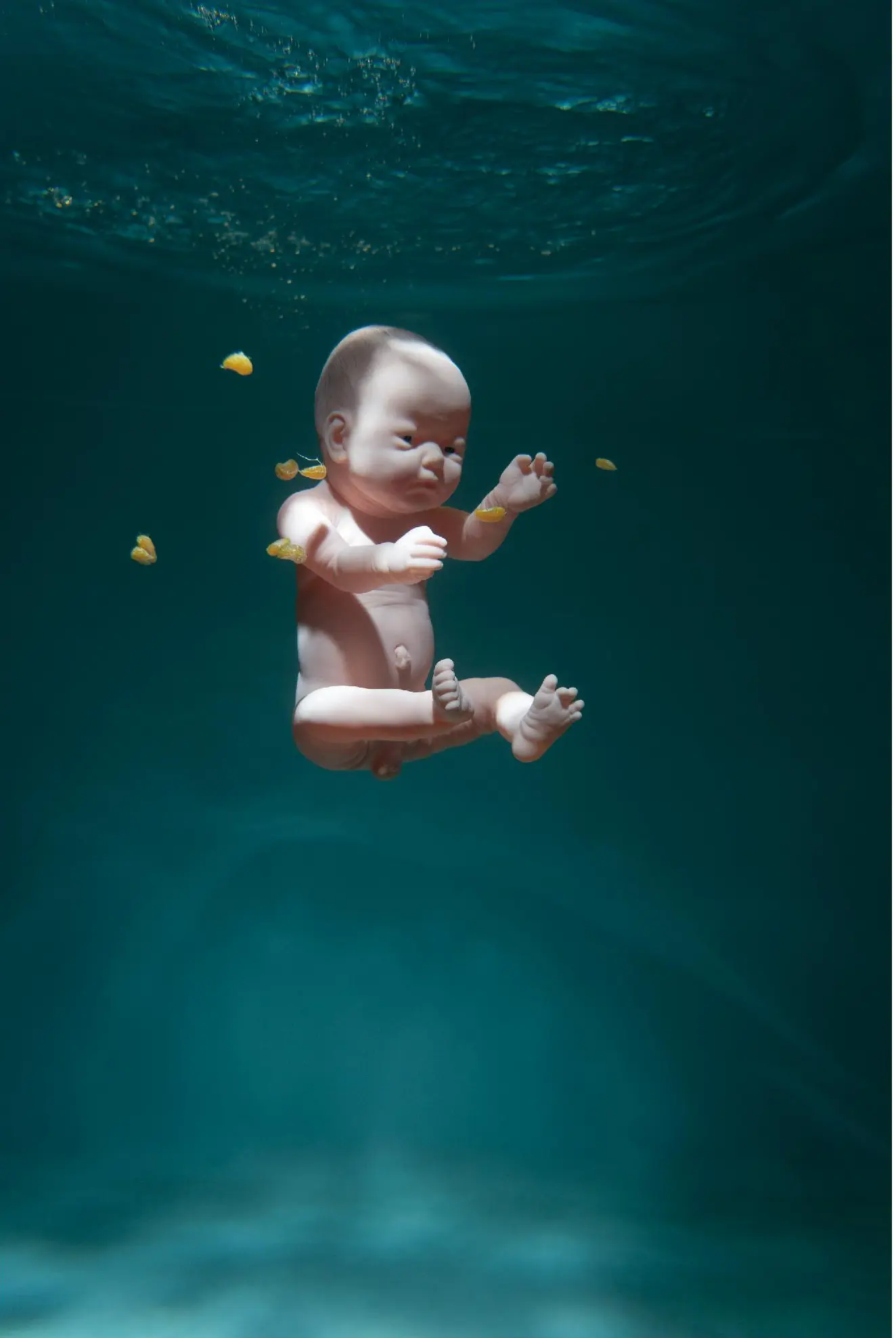 A baby doll and small fragments suspended underwater
